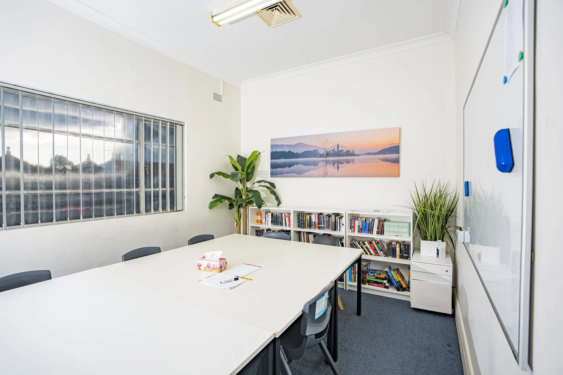 A small-group classroom with a table, chairs and bookshelf