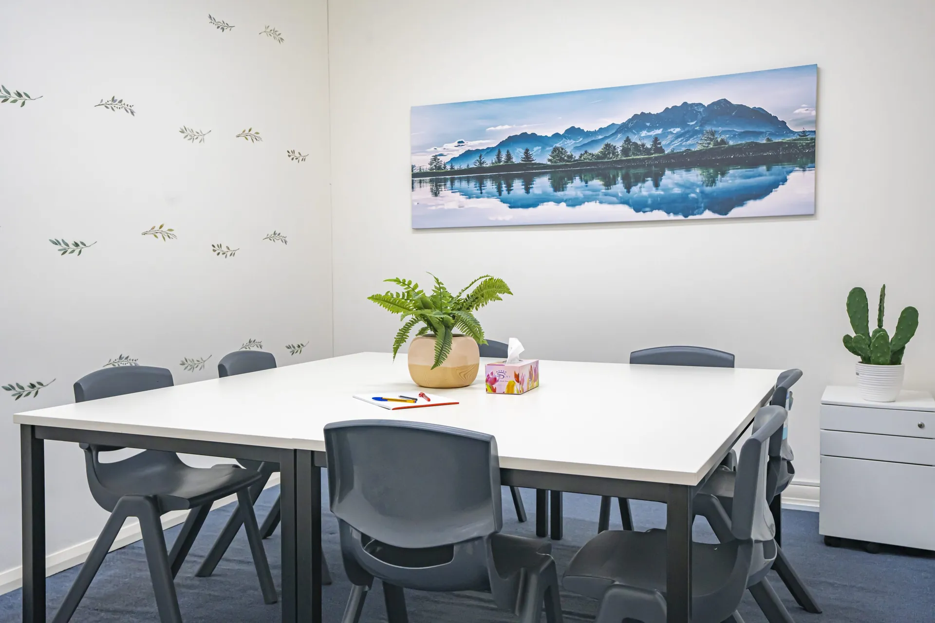 A classroom with whiteboard and landscape print