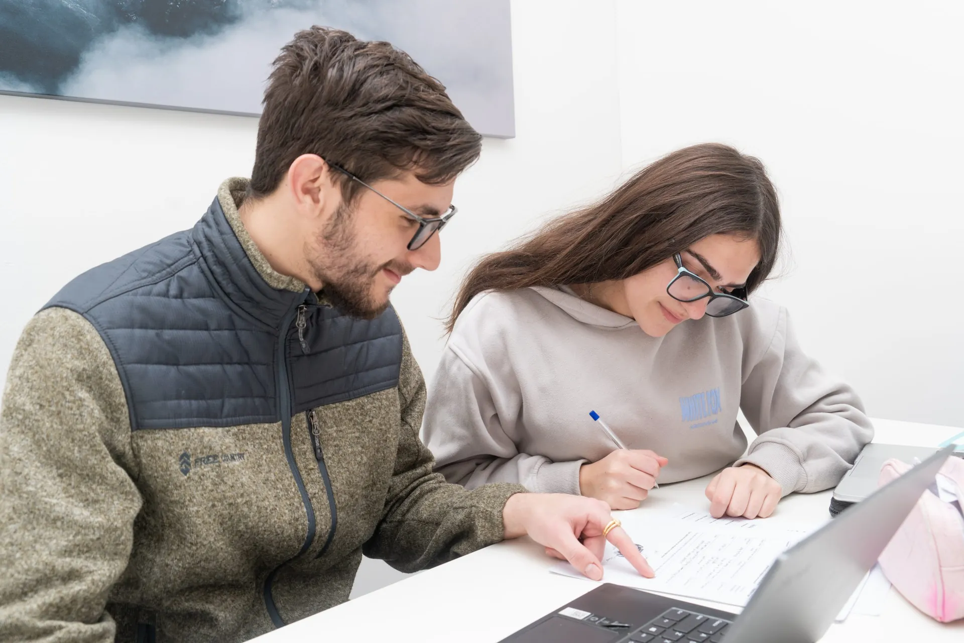 A tutor and student working together at a laptop